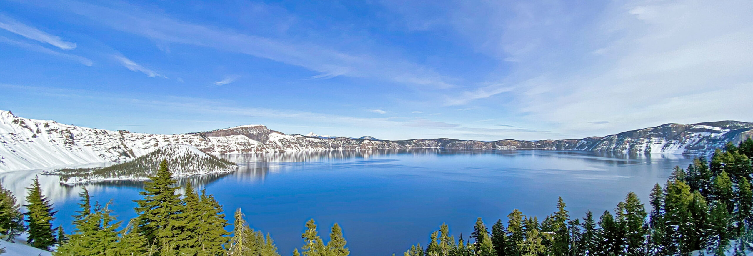 Oregon's Crater Lake in winter with blue sky and snow.