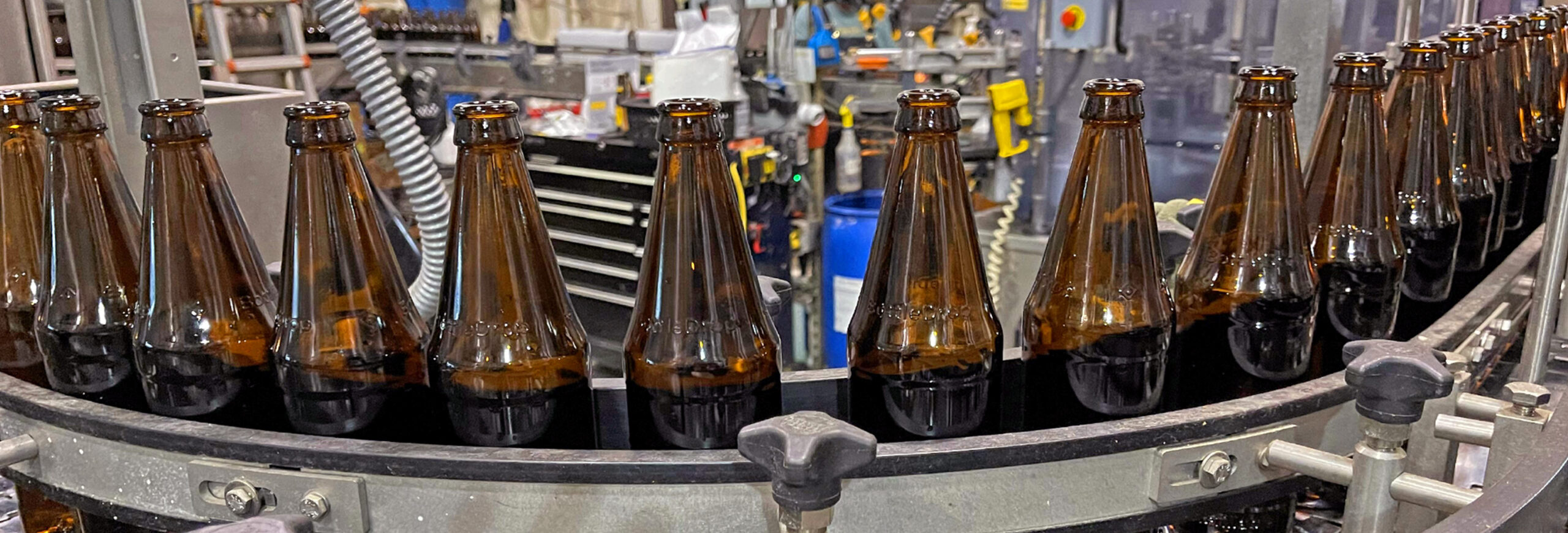 Brown refillable glass bottles in a cleaning line.
